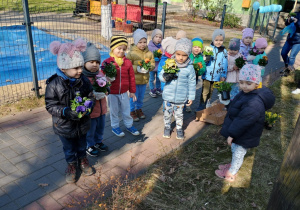 Dzieci pozują do zdjęcia z kwiatami