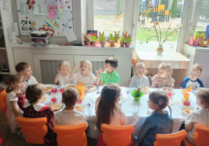 Dzieci siedzą przy wielkanocnym stole