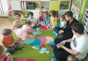 Dziewczynka układa ilustracje z pociętych elementów