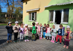 Dzieci pozują do zdjęcia ze swoimi kwiatkami w doniczce