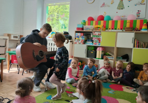 Dziewczynka ogląda gitarę