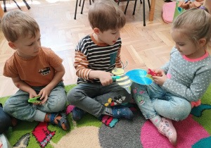 Dzieci za pomocą spinaczy przekazują sobie ilustrację pszczoły