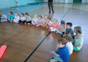 Dzieci siedzą na sali gimnastycznej