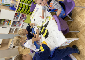 Dzieci malujące farbami bajkową postać Pszczółki Maji.
