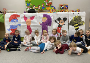 Grupa dzieci na tle pomalowanych przez siebie postaci.