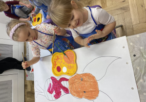 Dzieci malujące farbami bajkową postać Prosiaczka.