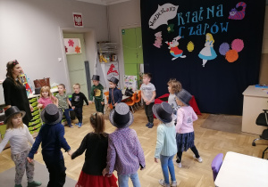 grupa dzieci tańcząca w kole z nauczycielem.