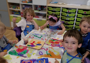 Dzieci malują farbami kolorowe cyfry