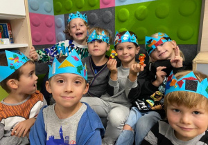 Grupa chłopców w niebieskich koronach na głowach.