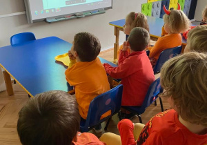 Dzieci oglądają prezentację na tablicy interaktywnej.