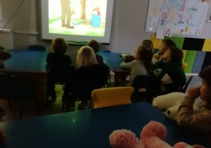 Dzieci oglądają bajkę po angielski na rzutniku.