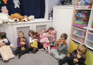 Dzieci przytulają swoje misie w sali.
