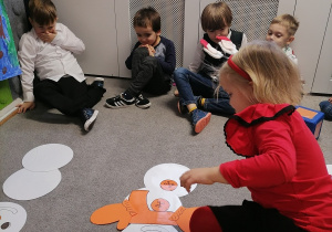 Dzieci kodują jak ubrać bałwanki za pomocą rzutów dużymi kostkami.