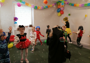 Dzieci bawią się, tańczą podczas balu karnawałowego.