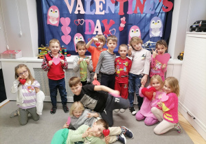 Grupa dzieci pozuje do zdjęcia na tle dekoracji z okazji Walentynek.