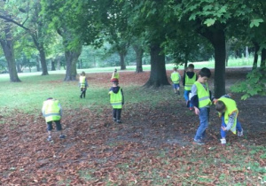 Dzieci biegające po paru wśród drzew.