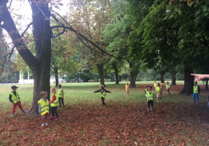 Dzieci biegające po paru wśród drzew.