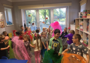 Dzieci tańczące z kolorowymi chustkami.