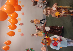 Dzieci w przebraniach bawiące się na balu jesieni.
