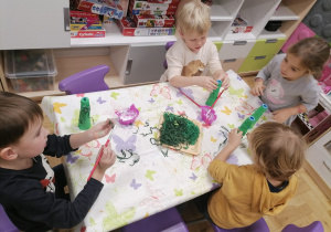 Dzieci wykonujące pracę plastyczną choineczki.