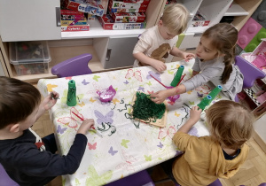 Dzieci wykonujące pracę plastyczną choineczki.