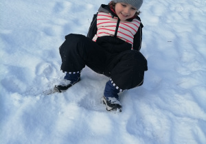 Chłopiec bawiący się w śniegu.