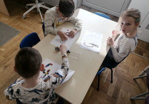 Dzieci wyklejające literę G za pomocą plasteliny.