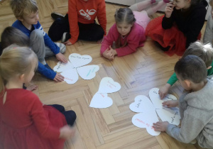 Dzieci układające czterolistne koniczyny z serc.