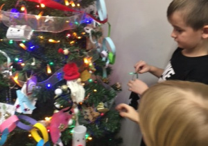 Dzieci tworzące dekoracje świąteczne z rodzicami.
