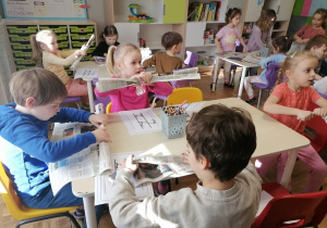 Dzieci tworzące literę Z z gazety.
