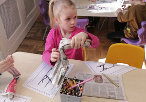 Dzieci tworzące literę Z z gazety.