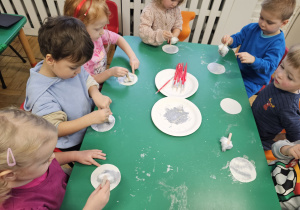 Dzieci malujące przy stoliku.