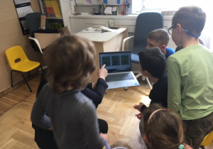 Dzieci oglądające prezentacje na laptopie.