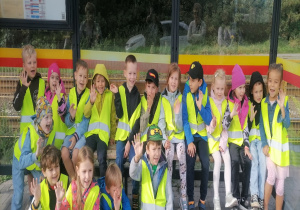 Dzieci pozują do zdjęcia na przystanku autobusowym