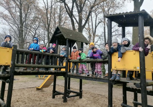 Cała grupa pozuje do zdjęcia na drewnianym zestawie ogrodowym