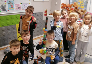 Dzieci budują z klocków na dywanie