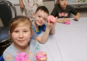 Dzieci bawią się przy stolikach piankoliną kolorową
