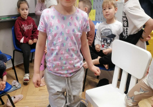 Dziewczynka pozuje do zdjęcia stojąc w garnku z kapustą