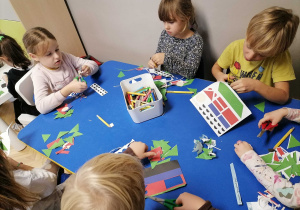 Dzieci tworzą mozaiki z figur geometrycznych