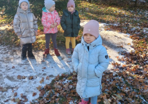 Dziewczynki stoją w ogrodzie przedszkolnym