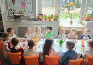 Dzieci siedzą przy wielkanocnym stole