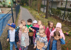 Dzieci pozują do zdjęcia z koszyczkiem pełnym jajek