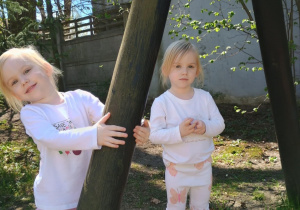 Dziewczynki pozują do zdjęcia w ogrodzie przedszkolnym