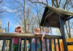 Dziewczynki pozują do zdjęcia na drewnianej konstrukcji