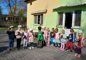 Dzieci pozują do zdjęcia ze swoimi kwiatkami w doniczce
