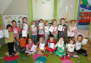 Dzieci pozują do zdjęcia ze swoimi pracami