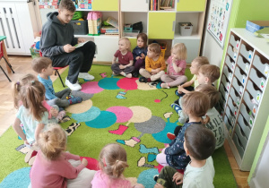 Uczeń Szkoły Podstawowej czyta dzieciom książkę