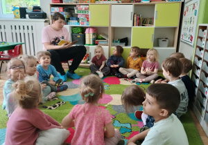 Uczeń Szkoły Podstawowej czyta dzieciom książkę