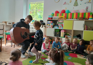 Dziewczynka ogląda gitarę