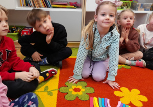 Dziewczynka układa i nazywa poszczególne kolory tęczy.